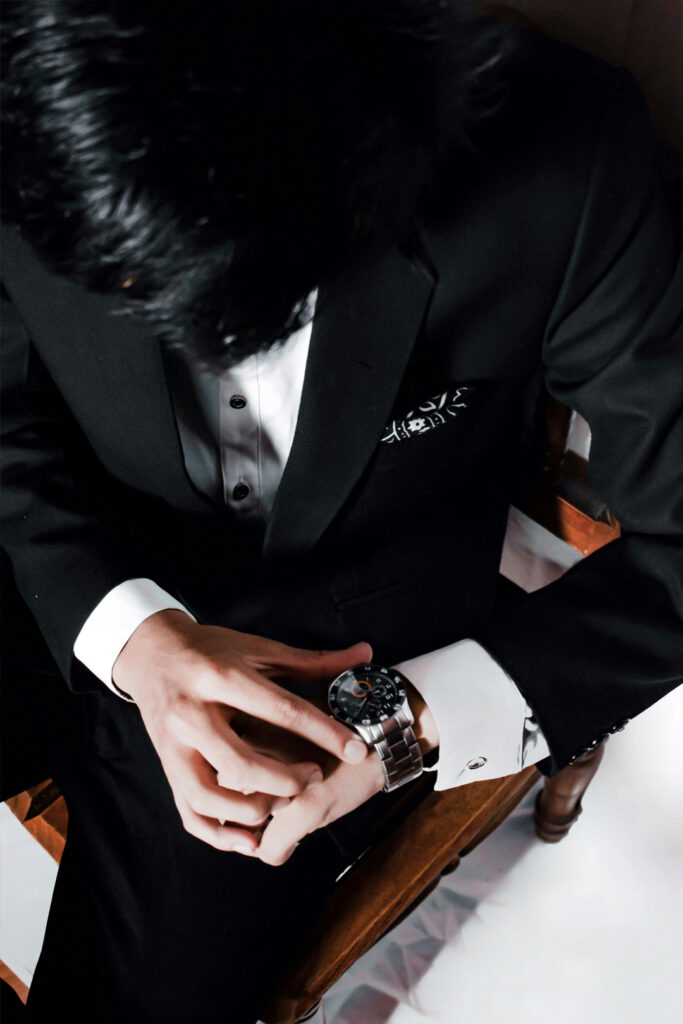 Man in suit looking at his Richard Mille watch